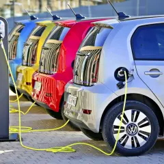 Kolorowe samochody elektryczne w Polsce ładowane na stacji.