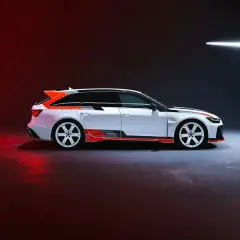 Białe Audi RS6 GT z pomarańczowymi akcentami i czarnymi pasami, gotowe do wyścigu.