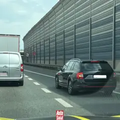 Korki na autostradzie, samochody stoją w rzędzie. Kierowcy czekają na możliwość zjazdu, stosując jazda na suwak.