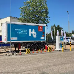 Naczepa z napisem "Zeroemisyjne paliwo wodorowe" i dystrybutor H₂. Wodór jako paliwo przyszłości.
