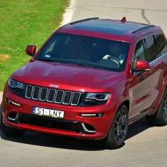 Czerwony Jeep Grand Cherokee na torze. Kierowca ma ciekawe tablice indywidualne pomysły, S1 LNY.