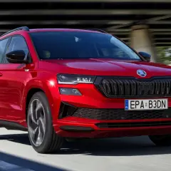 Czerwona Skoda Karoq w ruchu, z widocznym grillem i światłami. Poznaj jej wymiary i możliwości.