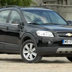 Czarny Chevrolet Captiva 2.0 diesel na tle opuszczonego budynku.