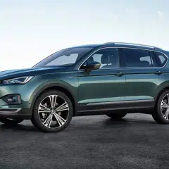 Zielony Seat Tarraco prezentuje swoje imponujące wymiary na tle górskiego krajobrazu.