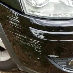 Widoczne liczne rysy na czarnym lakierze samochodu, wymagające usuwania rys z lakieru.