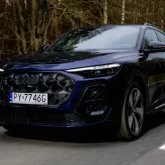 Ciemnoniebieskie Audi Q5 na drodze leśnej, z naciskiem na jego dynamiczny wygląd i potencjalne audi q5 spalanie.