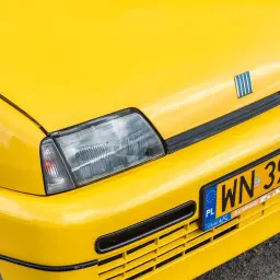 Żółta tablica rejestracyjna z numerem WN 39W na zderzaku jaskrawożółtego Fiata.