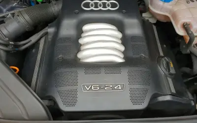 Silnik V6 2.4 w Audi A4 B6. Widoczna osłona silnika z logo Audi i oznaczeniem V6-2.4.