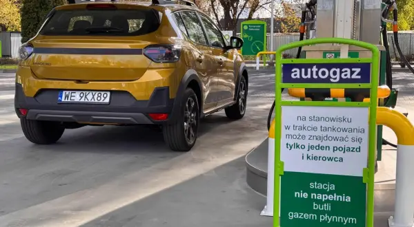 Żółty Dacia Sandero Stepway na stacji autogazu. Kierowca sprawdza dacia sandero stepway spalanie przed tankowaniem.