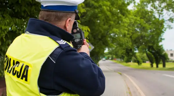 Policjant mierzy prędkość. Uważaj, bo za przekroczenie prędkości o 20 km/h czeka mandat.