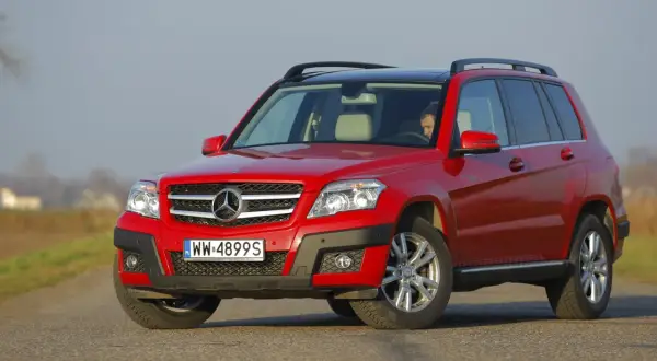 Czerwony Mercedes GLK na drodze. Poznaj jego kompaktowe wymiary i wszechstronność.
