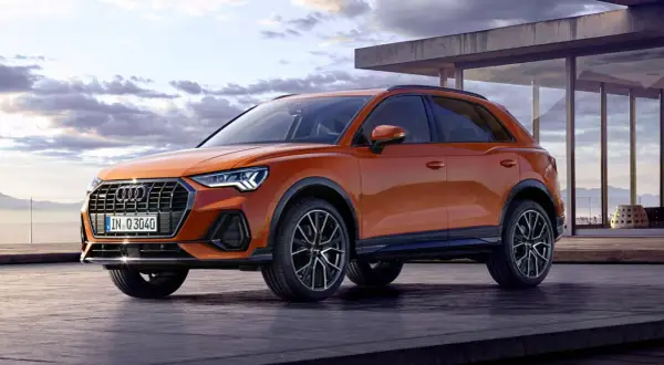 Pomarańczowe Audi Q3 na tarasie z widokiem na góry. Zastanawiasz się nad jego spalaniem?