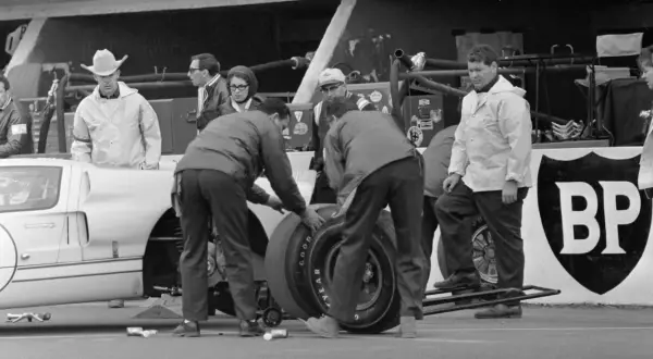 Zespół mechaników przy Fordzie GT40 podczas wyścigu Le Mans 1966. W tle widać kierowcę w kapeluszu kowbojskim.