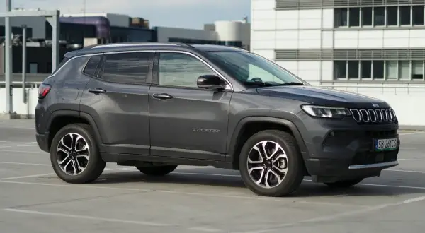 Szary Jeep Compass na parkingu. Zastanawiasz się nad jego spalaniem? Ten model oferuje dobre osiągi i komfort jazdy.