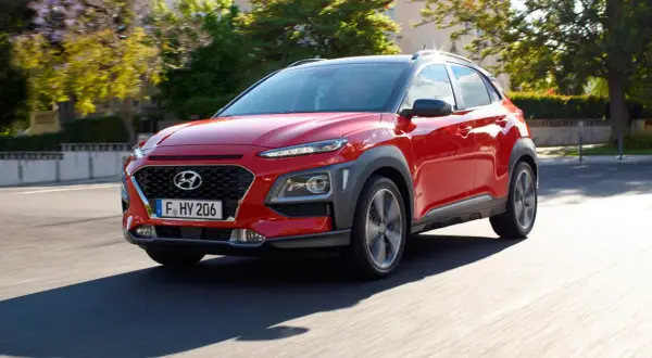 Czerwony Hyundai Kona w ruchu ulicznym. Sprawdź jego kompaktowe hyundai kona wymiary, idealne do miasta.