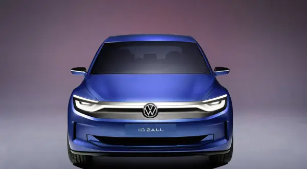 Niebieski Volkswagen ID.2ALL, jeden z nowych modeli marki, prezentuje futurystyczny design z charakterystycznym oświetleniem LED.