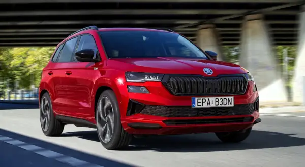 Czerwona Skoda Karoq w ruchu, z widocznym grillem i światłami. Poznaj jej wymiary i możliwości.