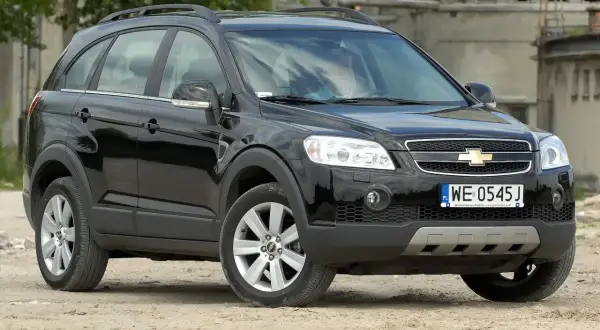 Czarny Chevrolet Captiva 2.0 diesel na tle opuszczonego budynku.