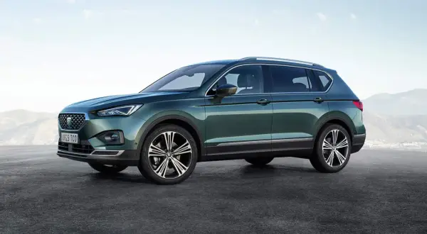 Zielony Seat Tarraco prezentuje swoje imponujące wymiary na tle górskiego krajobrazu.