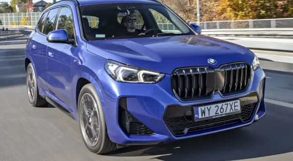 Niebieskie BMW X1 w ruchu drogowym, kierowca w okularach. Zastanawiasz się nad jego spalaniem?