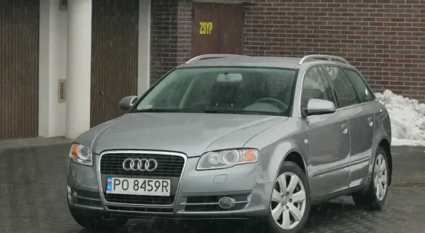Srebrne Audi A4 B7 Avant na tle ceglanego budynku. Sprawdź audi a4 b7 wymiary, by poznać jego gabaryty.