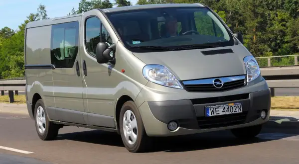 Opel Vivaro w kolorze szampańskim na drodze. Kierowca i pasażer w środku. Zastanawiasz się nad opel vivaro spalanie?