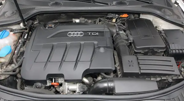 Silnik TDI w Audi A3. Widoczny czarny, plastikowy dekiel z logo Audi i napisem TDI.