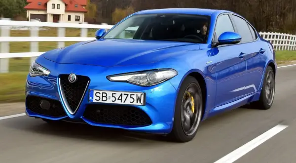 Niebieskie Alfa Romeo Giulia w ruchu, z widocznymi detalami, które mogą być interesujące dla osób szukających informacji o alfa romeo giulia dane techniczne.