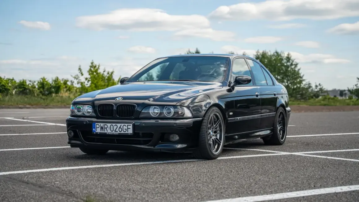Czarny, lśniący **BMW E39 M5** na parkingu, gotowy do jazdy.