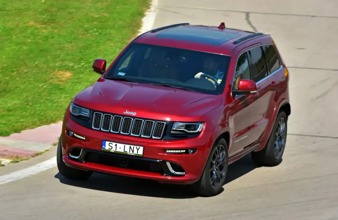 Czerwony Jeep Grand Cherokee na torze. Kierowca ma ciekawe tablice indywidualne pomysły, S1 LNY.