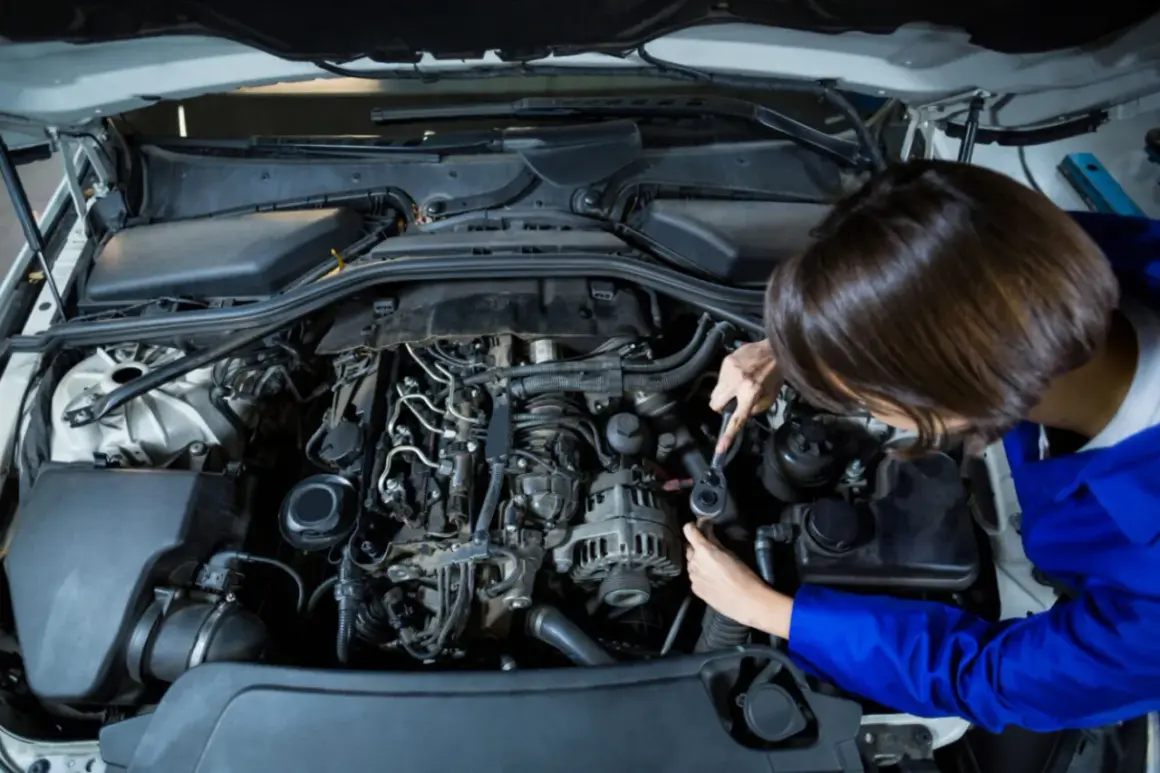 Mechanik naprawia silnik, gdy auto nie ma mocy benzyna.