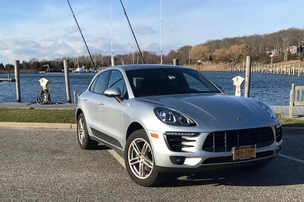 Srebrne Porsche Macan na tle przystani. Zastanawiasz się nad jego porsche macan spalanie?