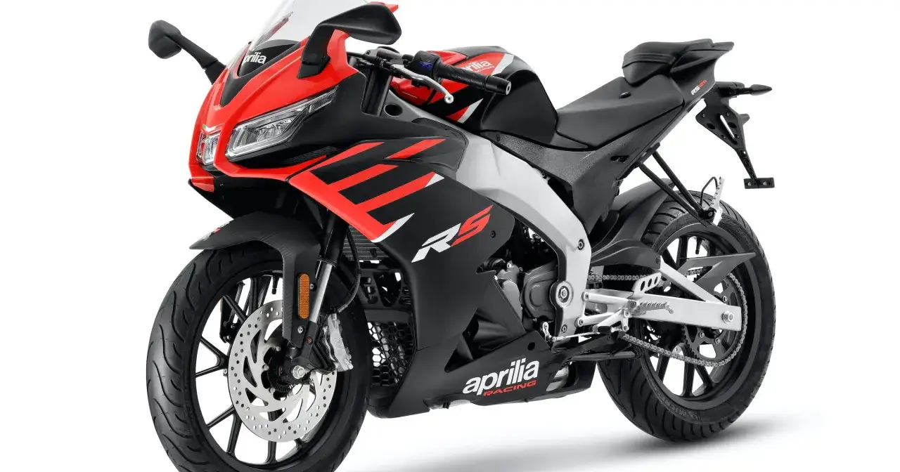 Sportowy motor Aprilia RS 125 w czerwono-czarnych barwach, idealny dla początkujących kierowców, którzy nie posiadają prawa jazdy na większe maszyny.