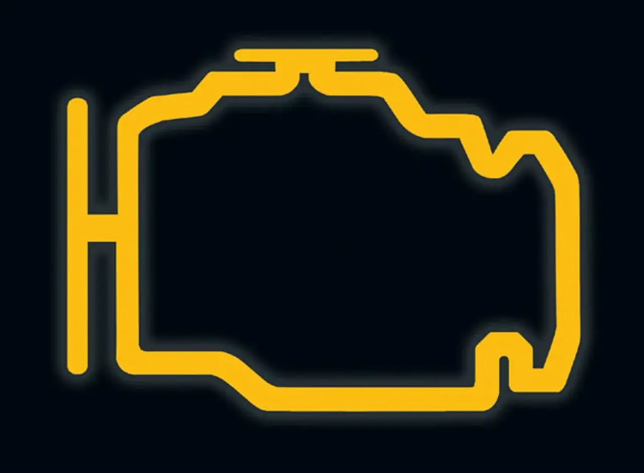 Żółta kontrolka check engine świeci się na ciemnym tle, sygnalizując problem z silnikiem.