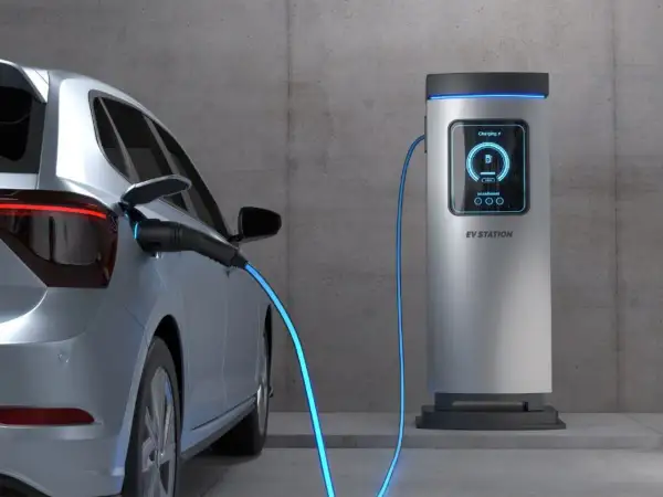 Samochód elektryczny podłączony do stacji ładowania. Sprawdź aktualne ceny ładowania samochodów elektrycznych, aby zaplanować podróż.