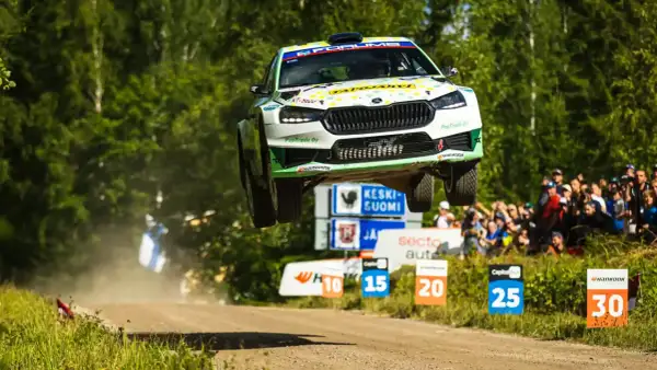 Skoda Fabia Rally 2 w locie nad ziemią, z widownią w tle.